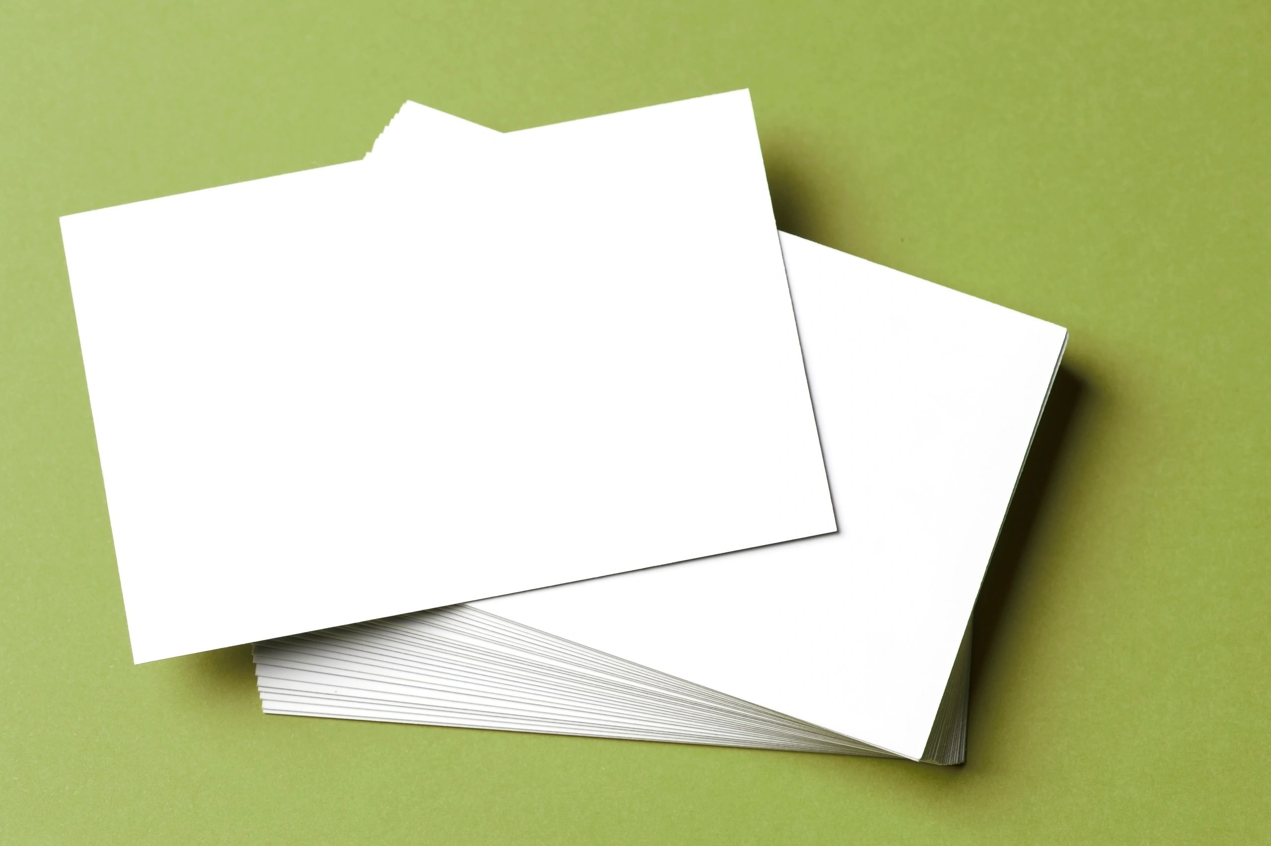 Stack of blank business cards on a green background