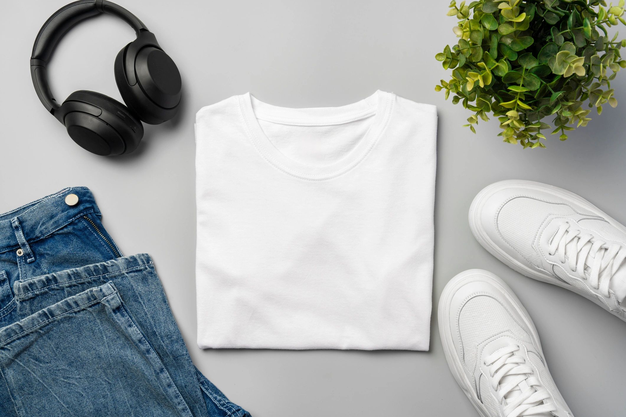 T-shirt flat lay with jeans and sneakers