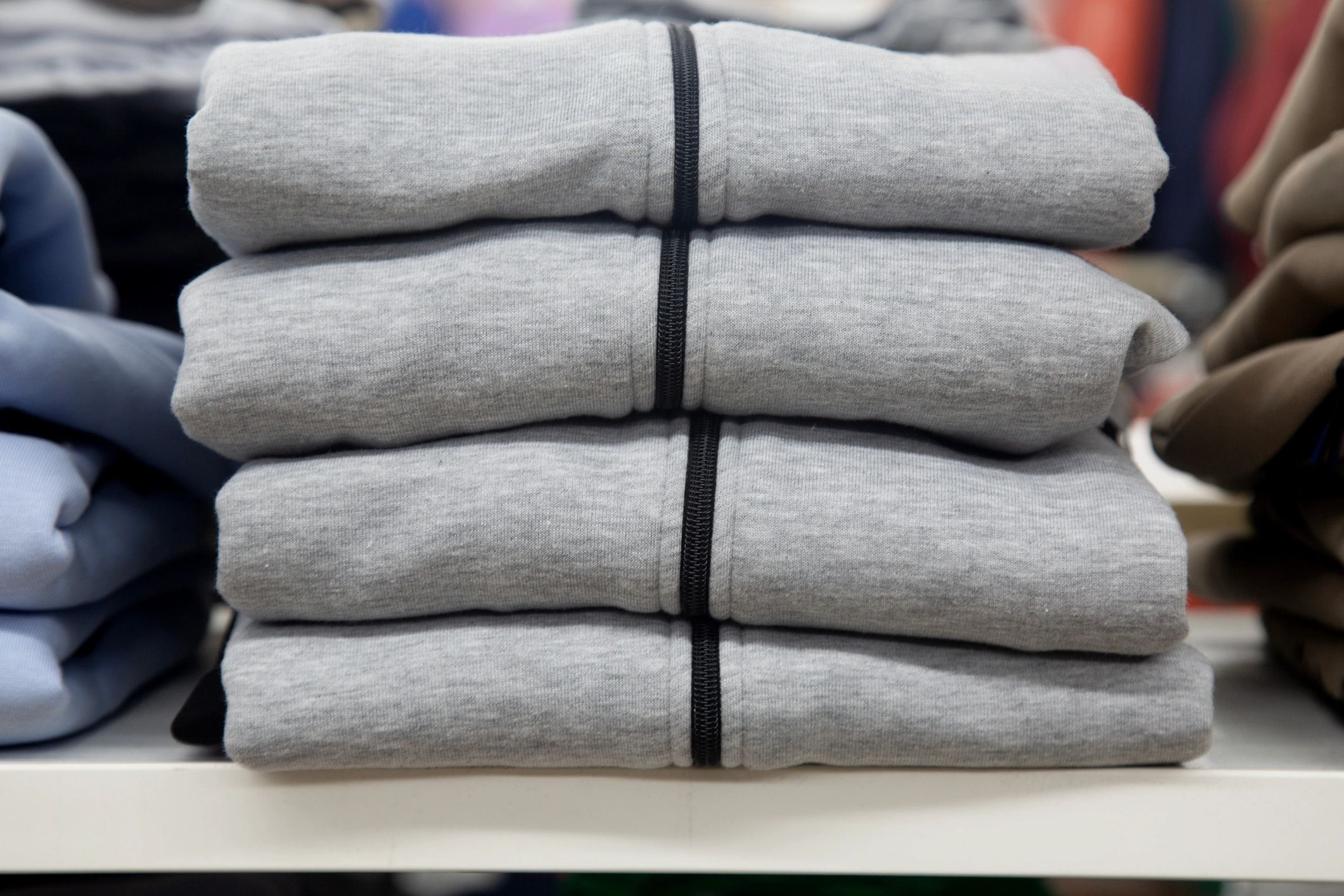 Neatly stacked colored shirts on a shelf