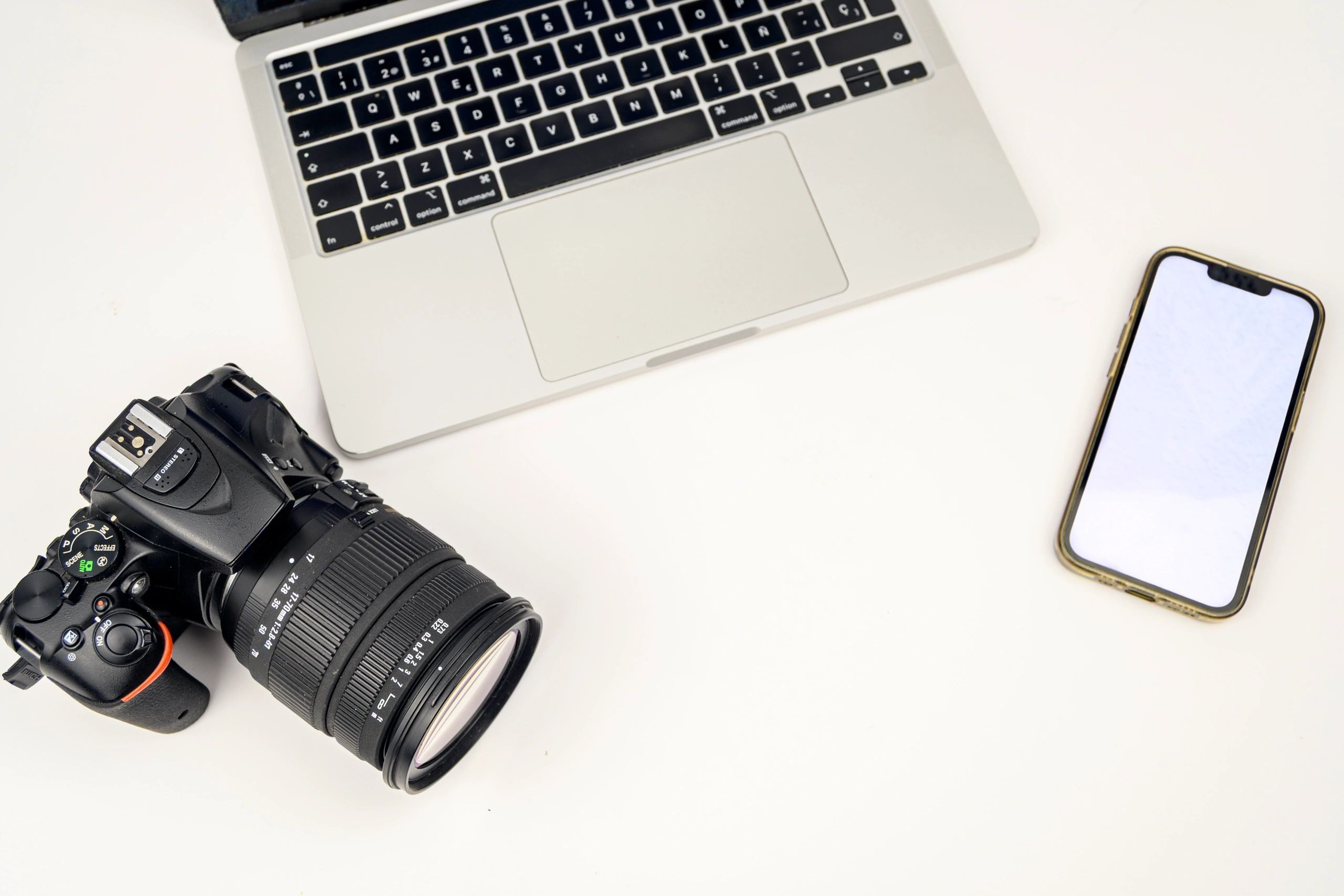 Minimal workspace with laptop, camera, and smartphone mockup for digital design